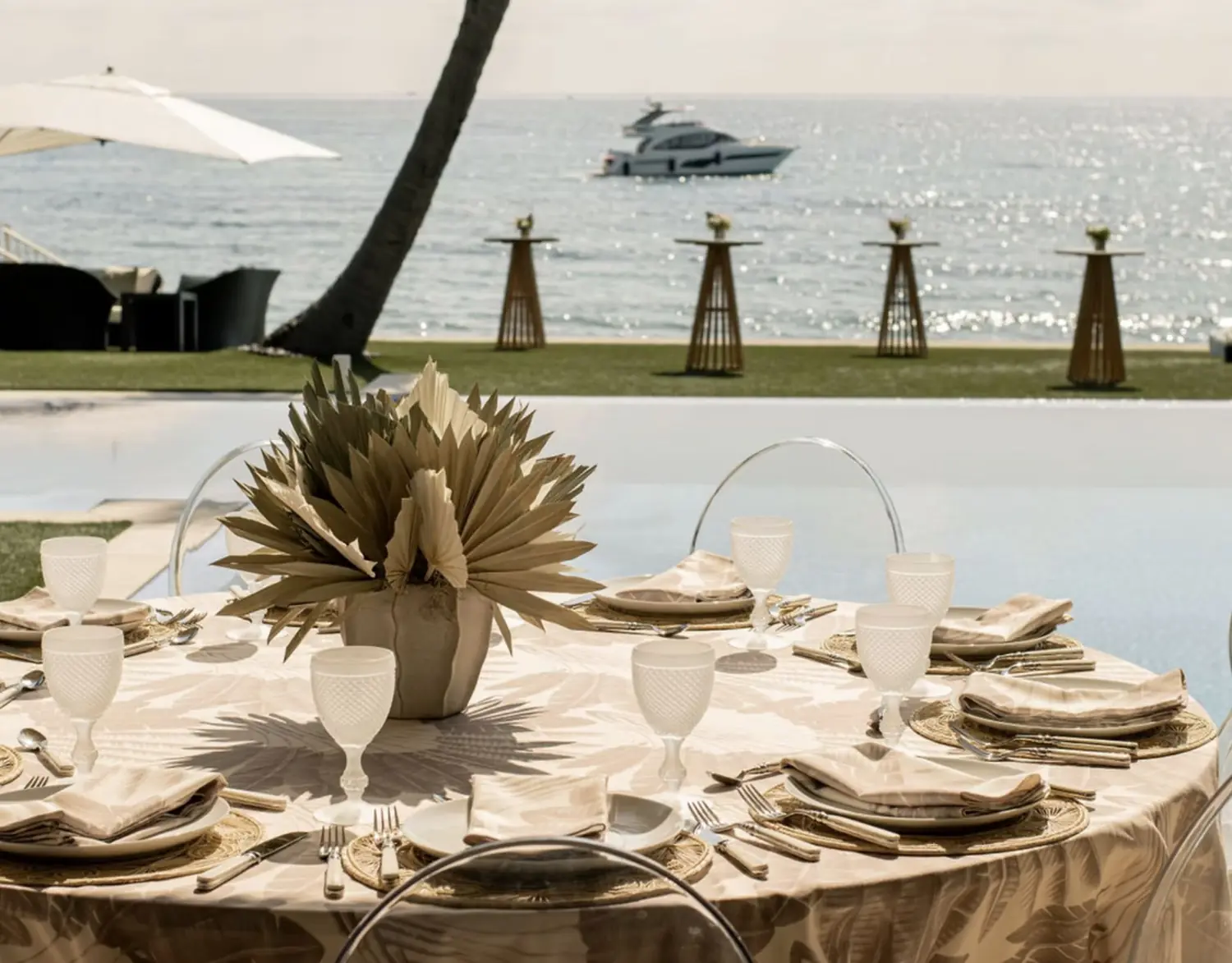 Waterfront table set by Silver Spoon Events with a private yacht offshore