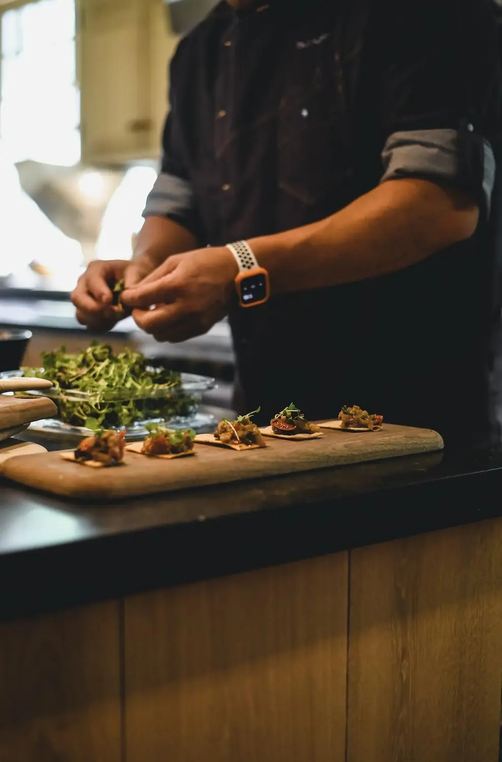 Chef Paul Aceto plating canapés in a private kitchen
